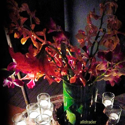 Orchid Centerpiece Idea 5 Orchids in a vase surrounded by candles.