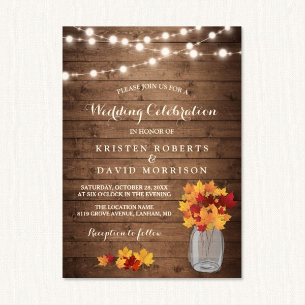 Autumn themed wedding invitations with string lights, wood grain and fall leaves in jar.