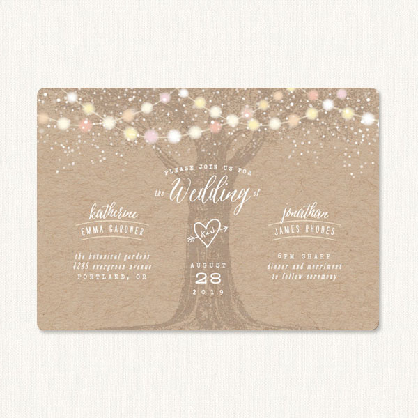 Garden light wedding invitations with a tree in the center, heart and arrow carving and colored string lights.