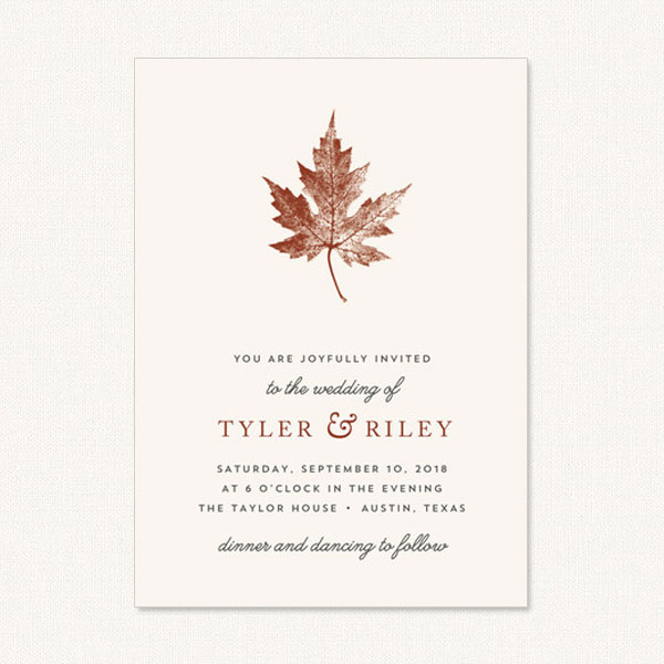 Unique fall wedding invitations with leaf print on cream background.