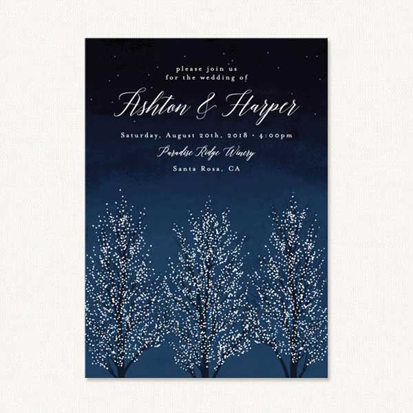 Winter themed wedding invites with trees covered in delicate snow.